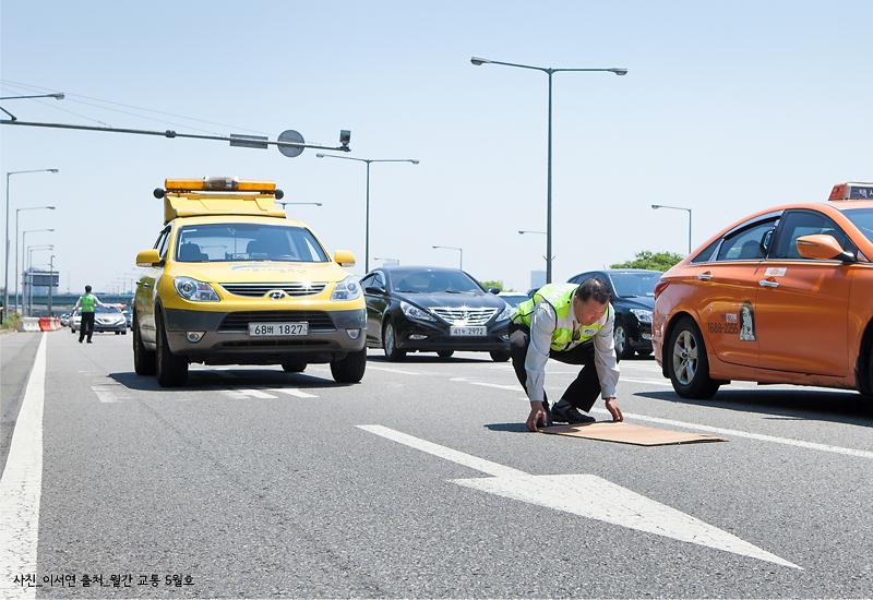 도로에 떨어진 합판을 제거하는 양승준 반장 모습